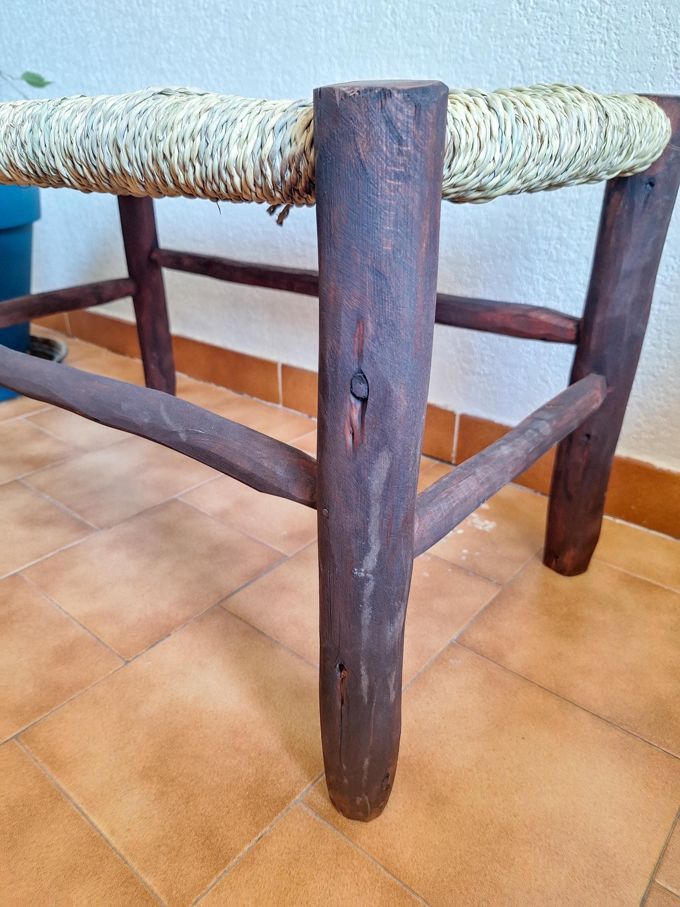Banc marocain en bois foncé et assise tressée en feuilles de palmier